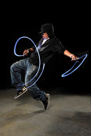 African American hip hop dancer with LED lights over dark background