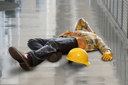 Injured construction worker laying on floor after fallの写真素材