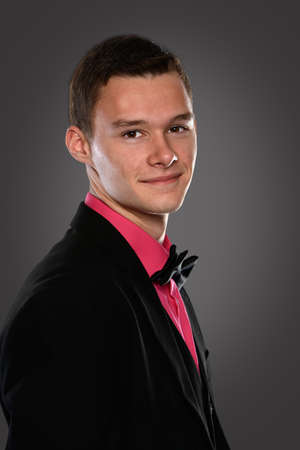 Portrait of young man with bow tie over brick backgroundの写真素材