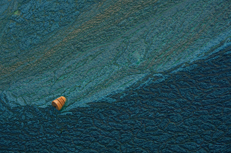 orange buoy in the water. sludge texture. Blue background.の写真素材