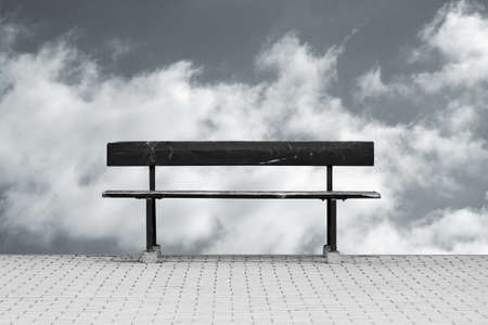 The photograph of a isolated park bench in front of a sky background                     の写真素材