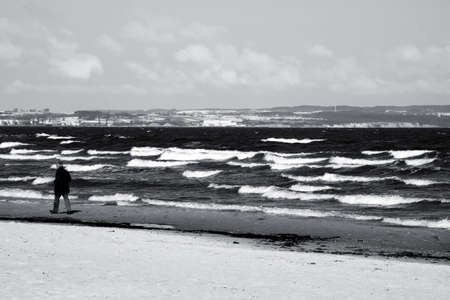 Binz, Mecklenburg-Western Pomerania / Germany  April 04, 2013: A man walks in stormy weather on the beach of the seaside resort Binz on April 04, 2013.                   のeditorial素材