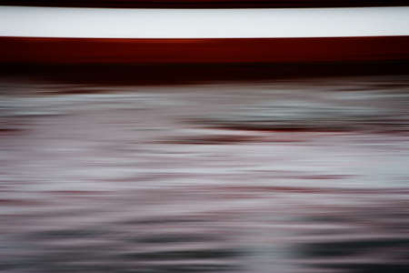 The long exposure of waves and a boat in a lake                      の写真素材