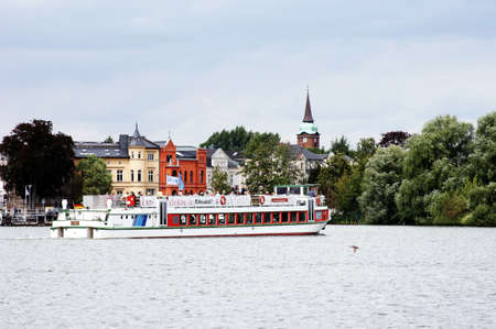 Schwerin, Germany - August 11, 2013  The round trip of a pleasure boats on Lake Schwerin with unknown persons on August 11, 2013 in Schwerin  On an island of the lake is the famous Schwerin Castle                 のeditorial素材