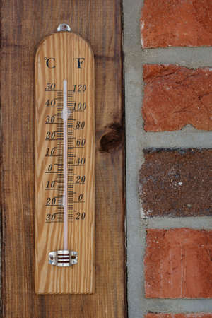 Close up of a thermometer on the outside of a brick wall                    