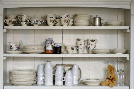 The photograph of an old kitchen shelf with cups and plates               の写真素材
