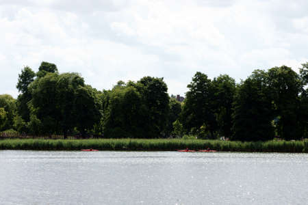 Three canoes sail along the shore of Lake Schwerin             の写真素材