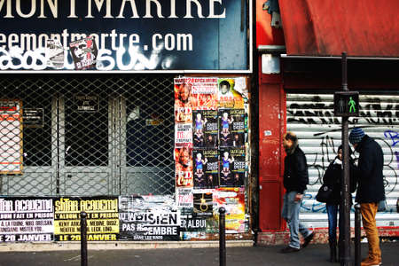 Paris, France - December 29, 2013  Pedestrians pass a shop and are standing at a traffic light in...