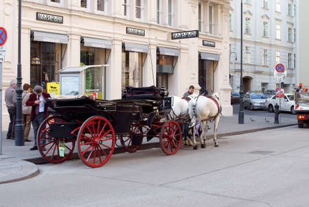 Vienna, Austria - March 30, 2014  A historic carriage drawn by two white horses on the roadside waiting for tourists for a city tour on March 30, 2014 in Vienna                のeditorial素材