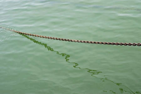 The photograph of a anchor chain in the water               の写真素材