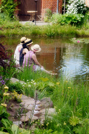 Biesendorf, Germany - June 15, 2014  Three singers sit in a garden pond during the event Open Gardens in Berlin Brandenburg on June 15, 2014 in Biesendorf                      のeditorial素材