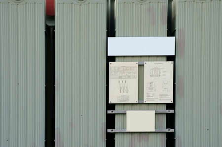 The photograph of the front of a 3-phase high voltage transformer with a circuit diagram.