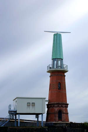 The photograph of a lighthouse with an installed radar system on the dome roof.の写真素材