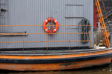 A maintenance cottage on the river bank with a rowing boat, safety equipment and building materials.の写真素材