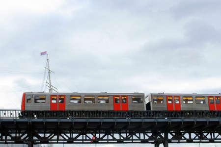 A tram crossing a bridge made of steel pillars.のeditorial素材