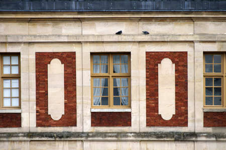 A nostalgic old residential house facade with sitting pigeons.のeditorial素材