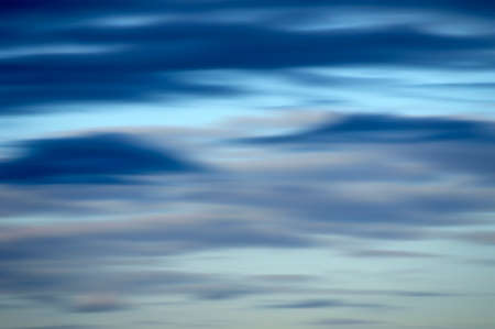 A blurred sky with different colored clouds.