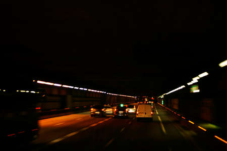 Car lights and traffic in a dark tunnel.の写真素材
