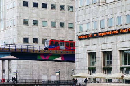 London, UK - November 28, 2014: A red subway DLR line passed on a bridge skyscraper in the financial...