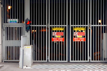 A car park entrance or driveway with a traffic light and a grid.のeditorial素材