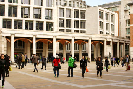 London UK April 01 2015: Pedestrians Travelers and business people on the square in front of the monument with shops and restaurants on April 01 2015 London.のeditorial素材