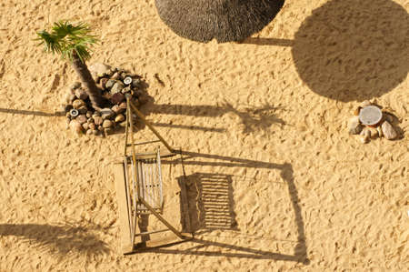 The aerial view and top view of a sandy beach with an umbrella and a palm tree.の写真素材