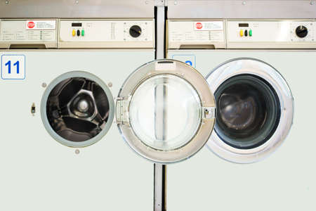 Two juxtaposed washing machines in a laundromat.の写真素材