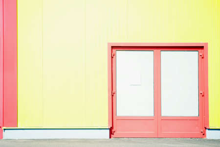 A colorful and striking sidewall of a shopping center with a side entrance, and by sunlight strong bright color.の写真素材