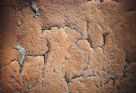 The closeup of peeling layers of plaster and paint on a concrete wall.の写真素材