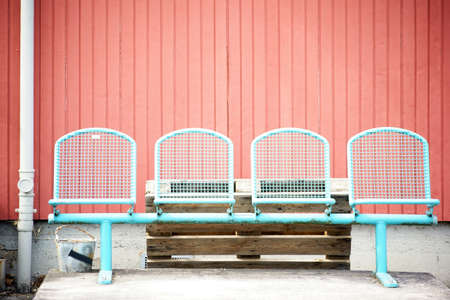 A number of lattice chairs faces a wooden shack with wooden walls.の写真素材