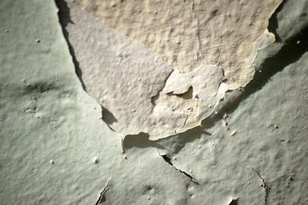 The closeup of chipped paint layers on the surface of a wall.