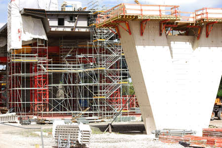 The construction of a new highway bridge with a V-shaped concrete beam and scaffolding.