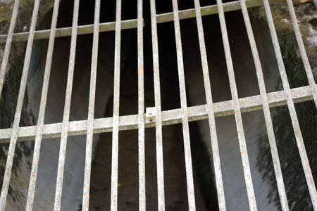 A drain or a drain pipe with an iron gate.