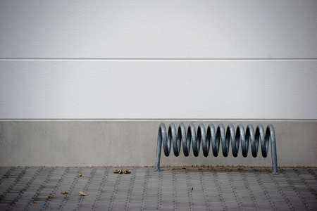 A spiral bicycle stands in front of the facade of a shopping center.