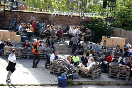 Mainz, Germany October 02, 2015: Teenage viewers and visitors sit on wooden pallets and beer at...