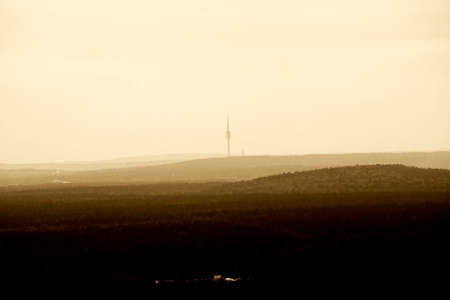 The Aerial view of forested hills with a transmission tower on the horizon.の写真素材