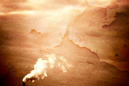 The sunlight illuminated smoky chimney of an industrial plant.の写真素材