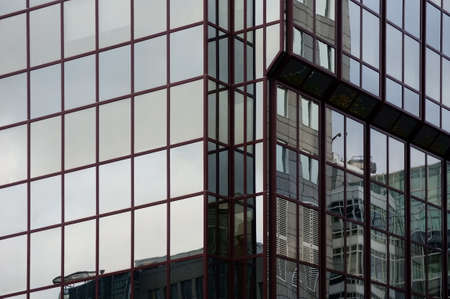 The reflection of buildings in the modern mirror facade of an office building and residential...