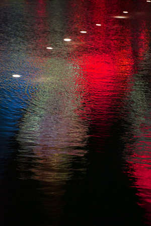 Abstract reflections and gradients on the smooth surface of a water body.