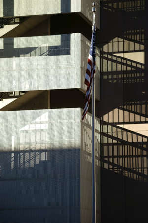 The facade of a modern residential building with a staircase, which casts a shadow.
