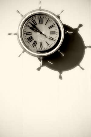 A ship's wheel was turned into a nostalgic maritime clock.の写真素材