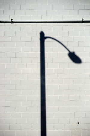 A distinctively curved Lantern shadow on a brick wall.の写真素材