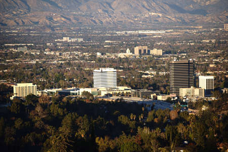 Several skyscrapers and shopping malls, surrounded by parks and hills in Los Angeles.の写真素材