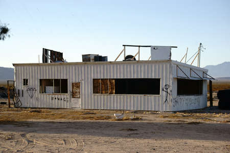 The sheet metal building of a former branch wasted in the desert.の写真素材