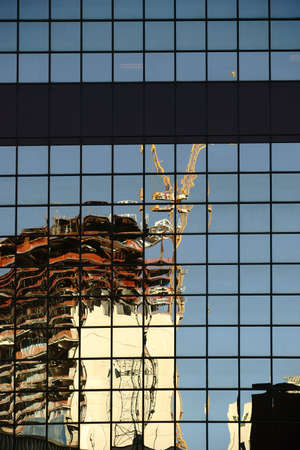 The irregular reflection of a construction crane in a mirror window facade.の写真素材