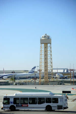 Los Angeles, United States - December 28, 2015: A bus with airport employees crosses the departure terminal of Israel airline with a lookout tower at airport LAX on December 28, 2015 Los Angeles.のeditorial素材