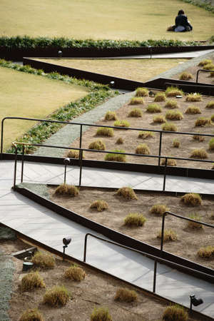 Los Angeles, United States - December 26, 2015: A museum visitor is sitting on a lawn in the Central Garden at the Getty Center created by Robert Irwin on December 26, 2015 in Los Angeles.のeditorial素材