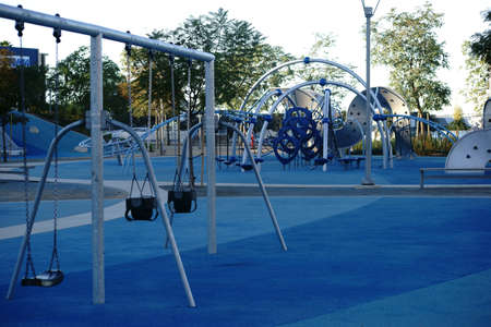 A modern playground in the city designed with rubber mats, swings and slides.の写真素材