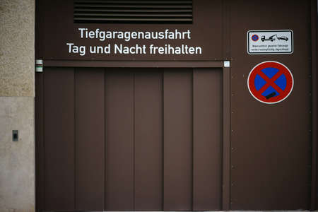 The exit of a parking garage with traffic signs and a sliding door.の写真素材