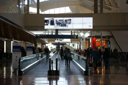 Los Angeles, United States - December 28, 2015: Travelers go on and off the next flat escalator of a departure terminal at LAX on December 28, 2015 Los Angeles.のeditorial素材